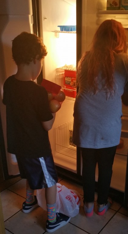 Brother and sister filling the fridge for the first time